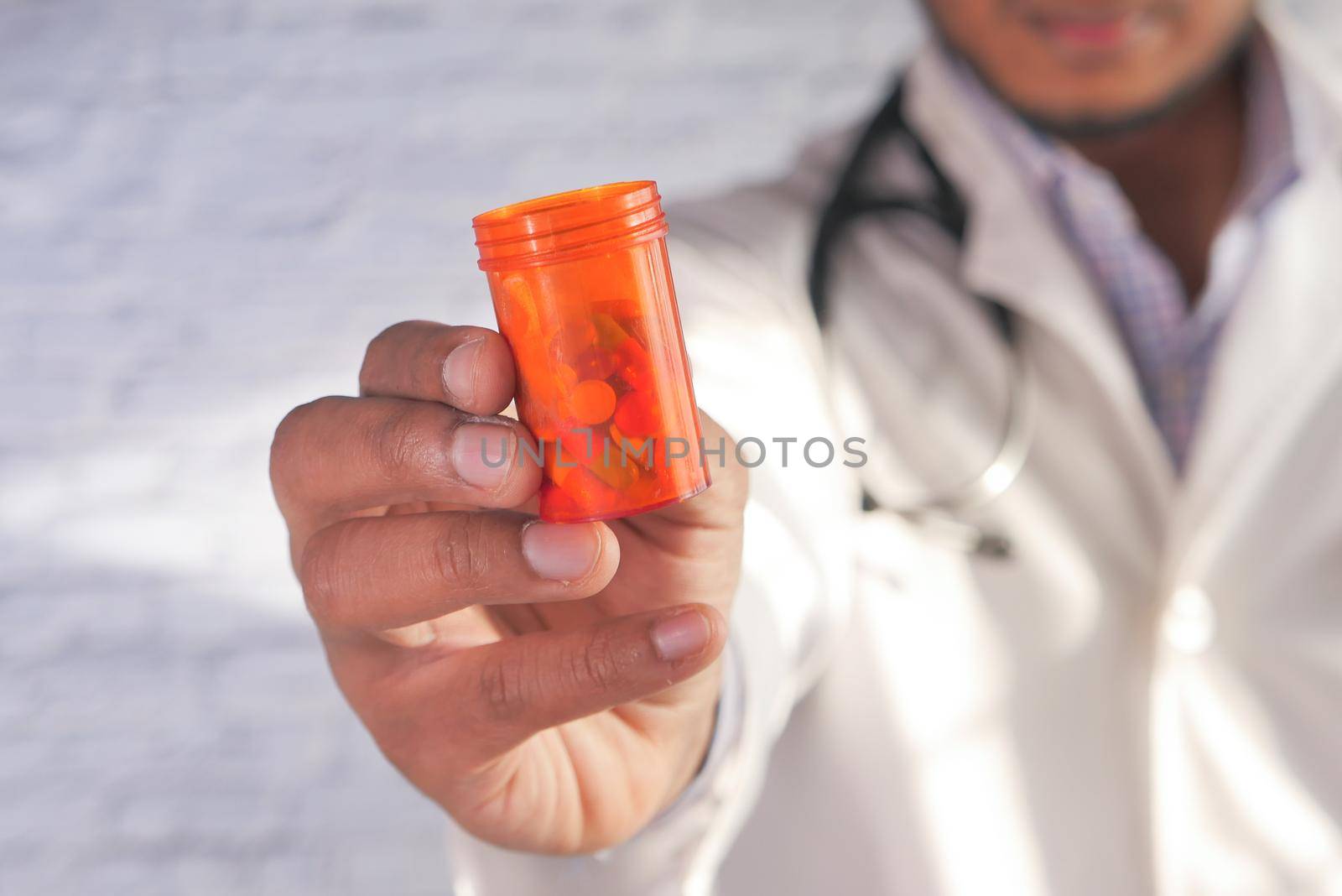 doctor hand holding pill container with copy space .