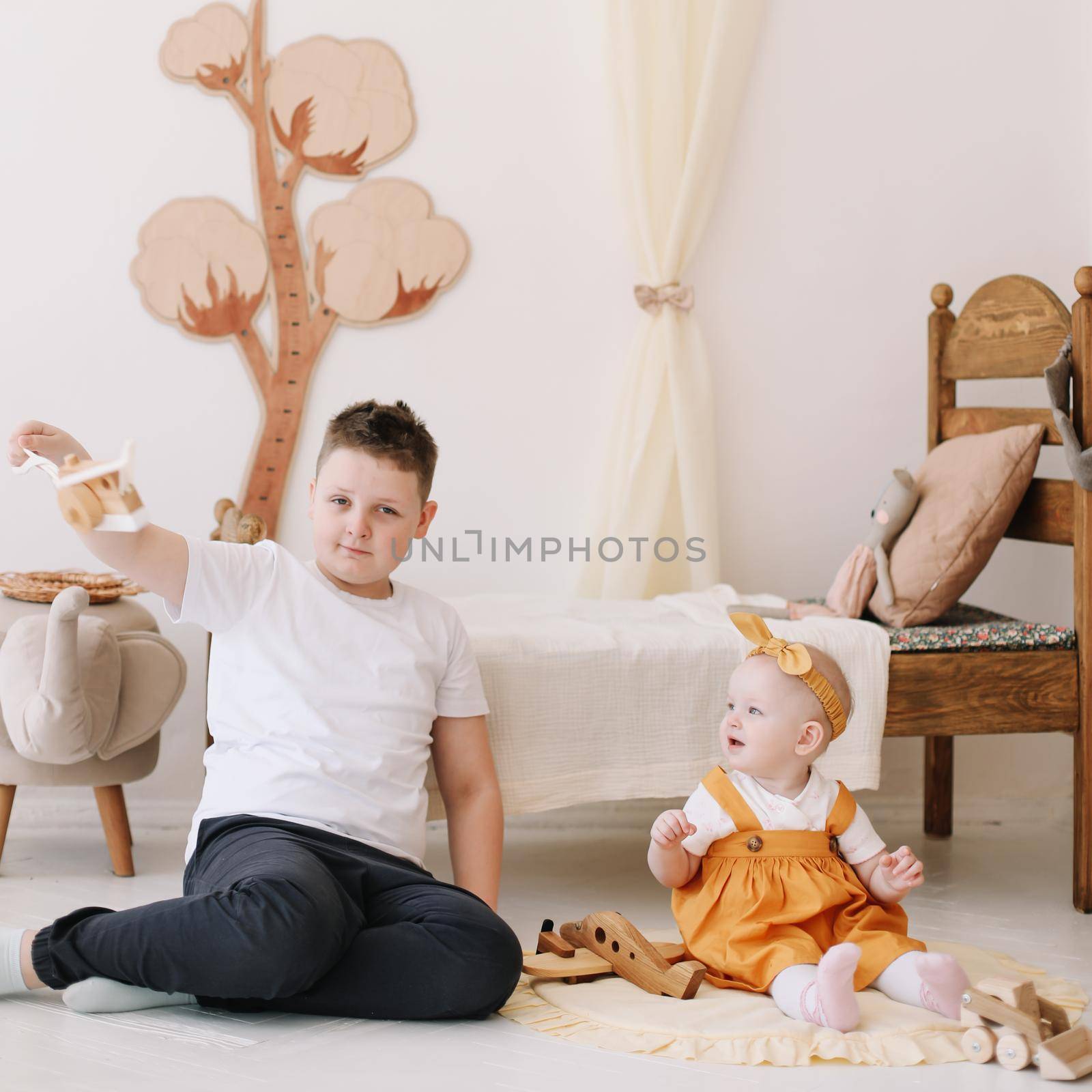 cute kids, siblings playing at home, elder brother and little sister in the nursery at home.