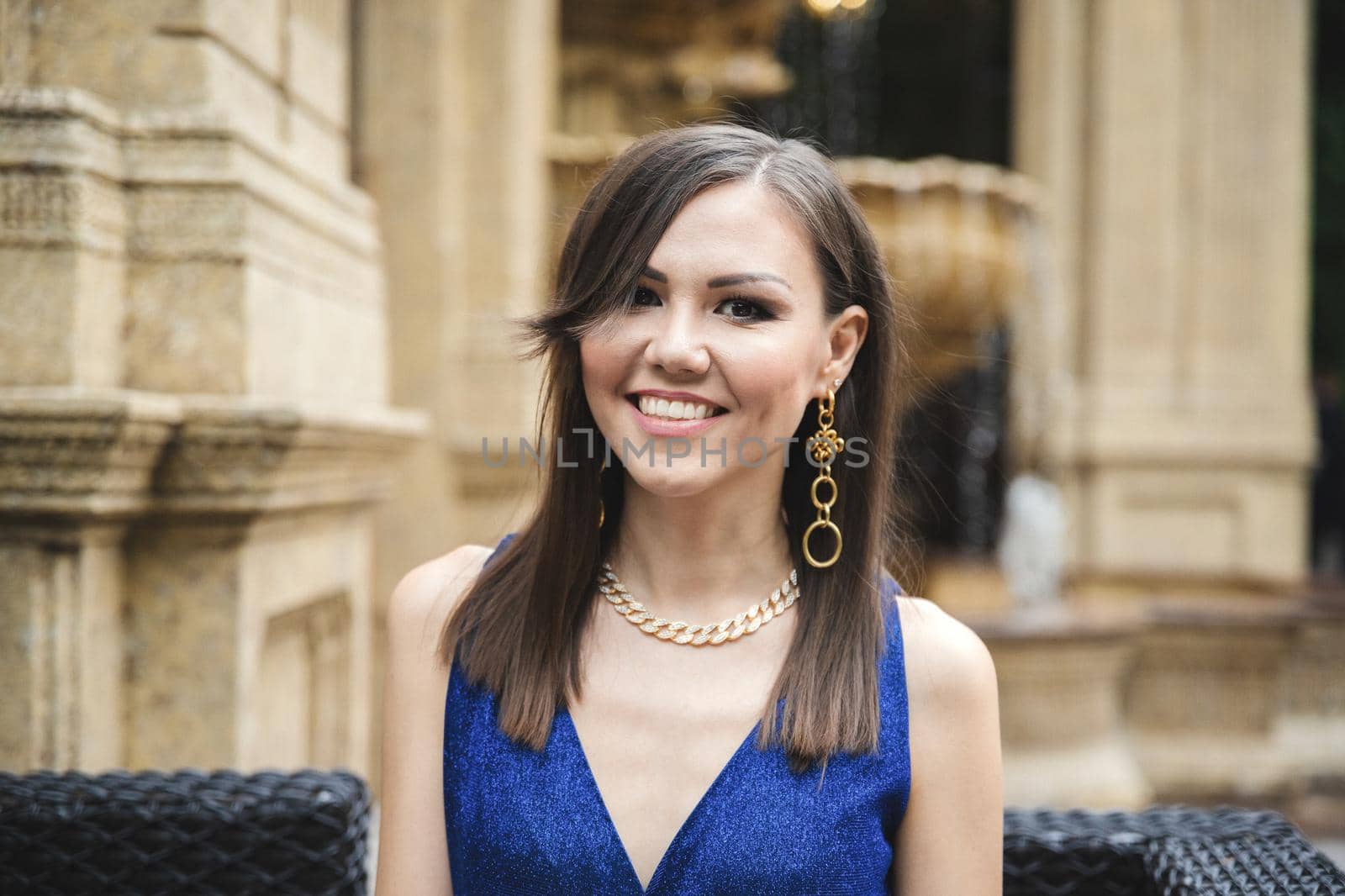 Multiracial pretty smiling woman in blue dress outdoor portrait.