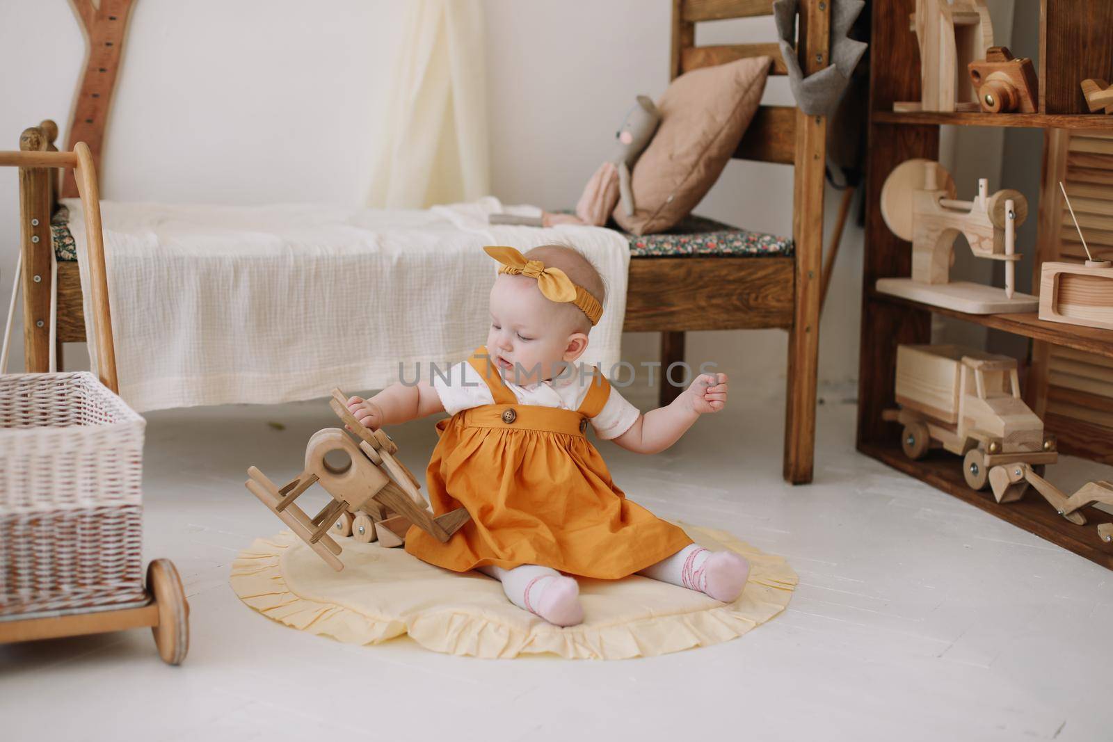 Adorable happy baby girl playing in a sunny room. Portrait of a happy child at home.