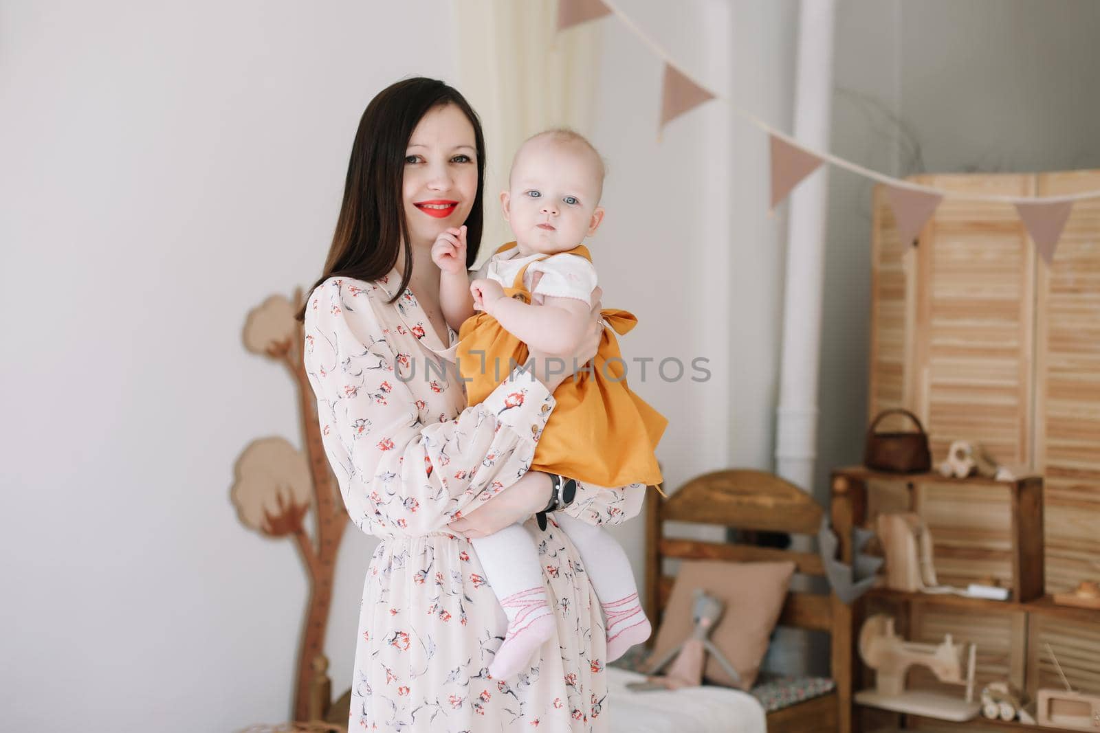 Happy mom holding and hugging little daughter, loving family sincere feelings. Mother and baby by paralisart