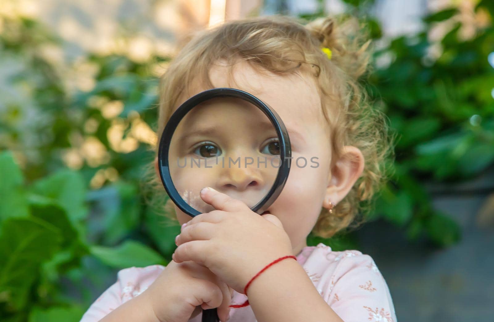 A child with a magnifying glass is studying the world. Selective focus. Kid.