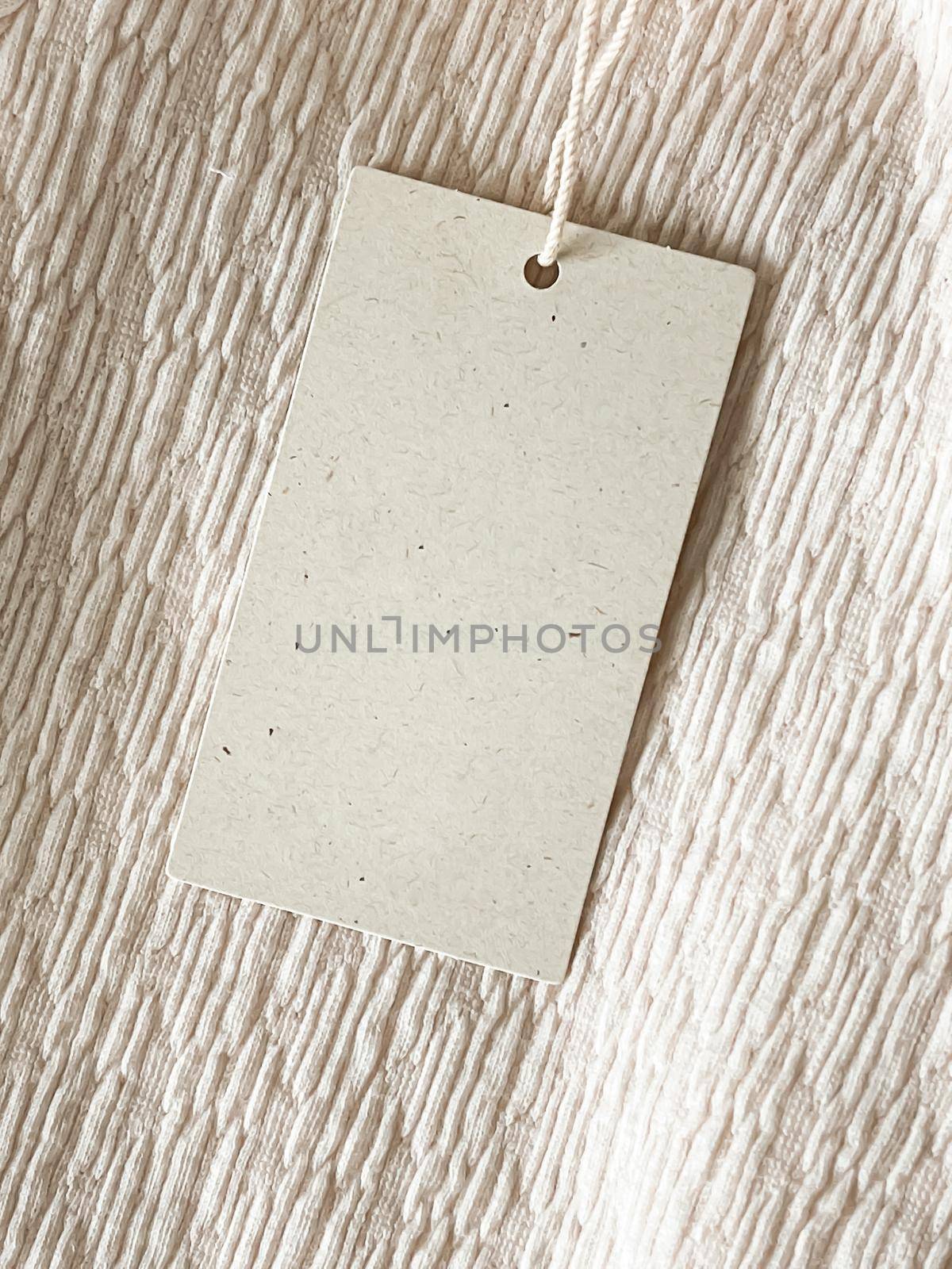 Blank fashion brand label tag, sale price card on luxury fabric background, shopping and retail concept