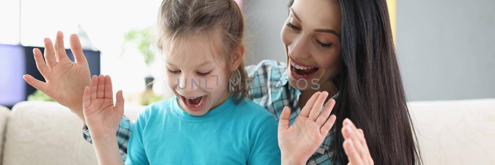 Portrait of happy surprised girl get present from mother, kid open eyes and see decorated box. Cheerful mum congratulate with birthday daughter. Party, gift, family, emotion concept