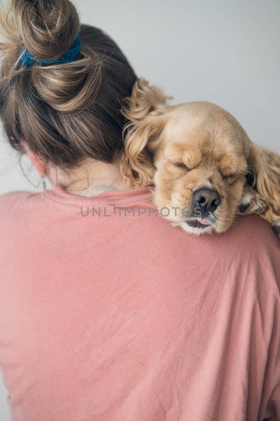 Young woman hugs her dog. The dog lies on the shoulder at a young woman by driver-s