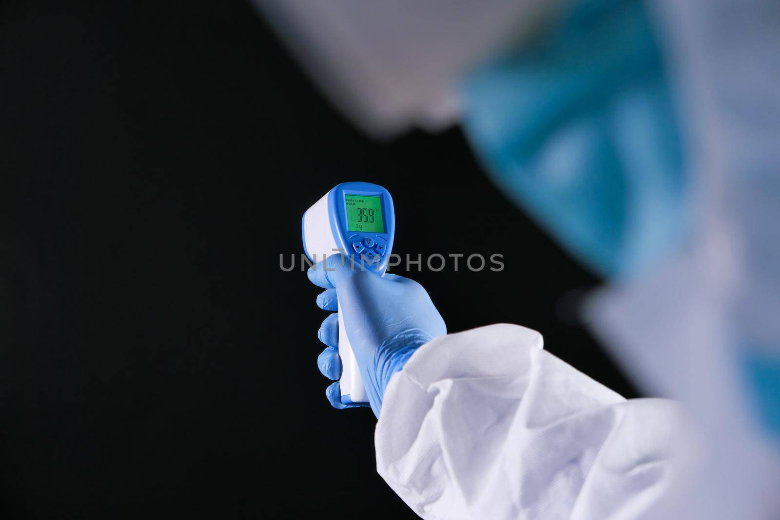 Hand holding infrared thermometer to measuring temperature