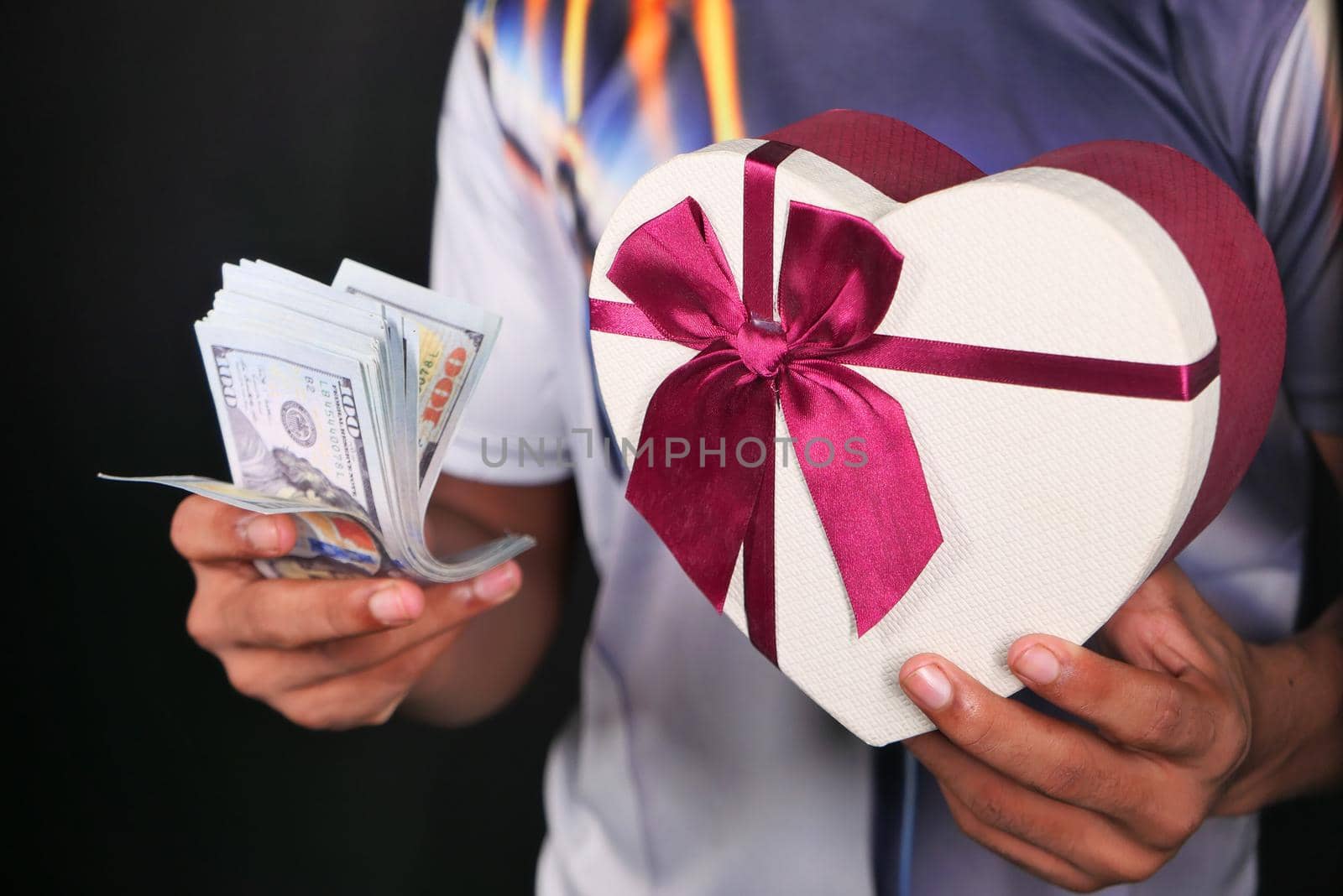 young man hand holding gift box and cash
