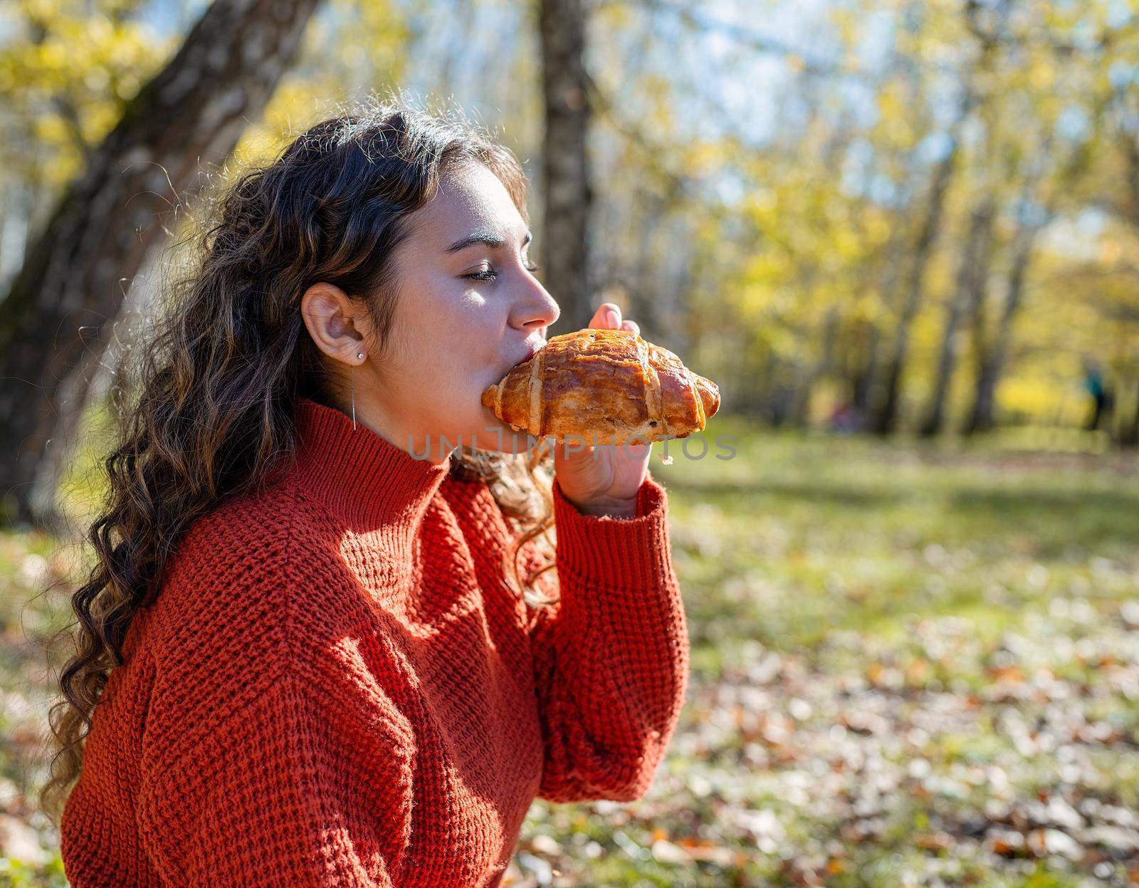 Beautiful woman in red sweater on a picnic in a autumn forest by Desperada