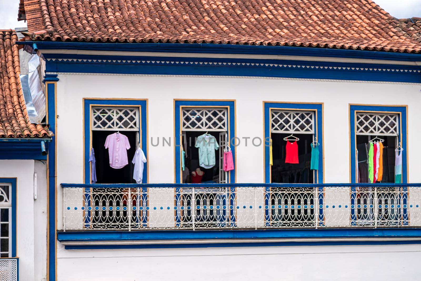 Colorful clothes in the windows of a historic building.