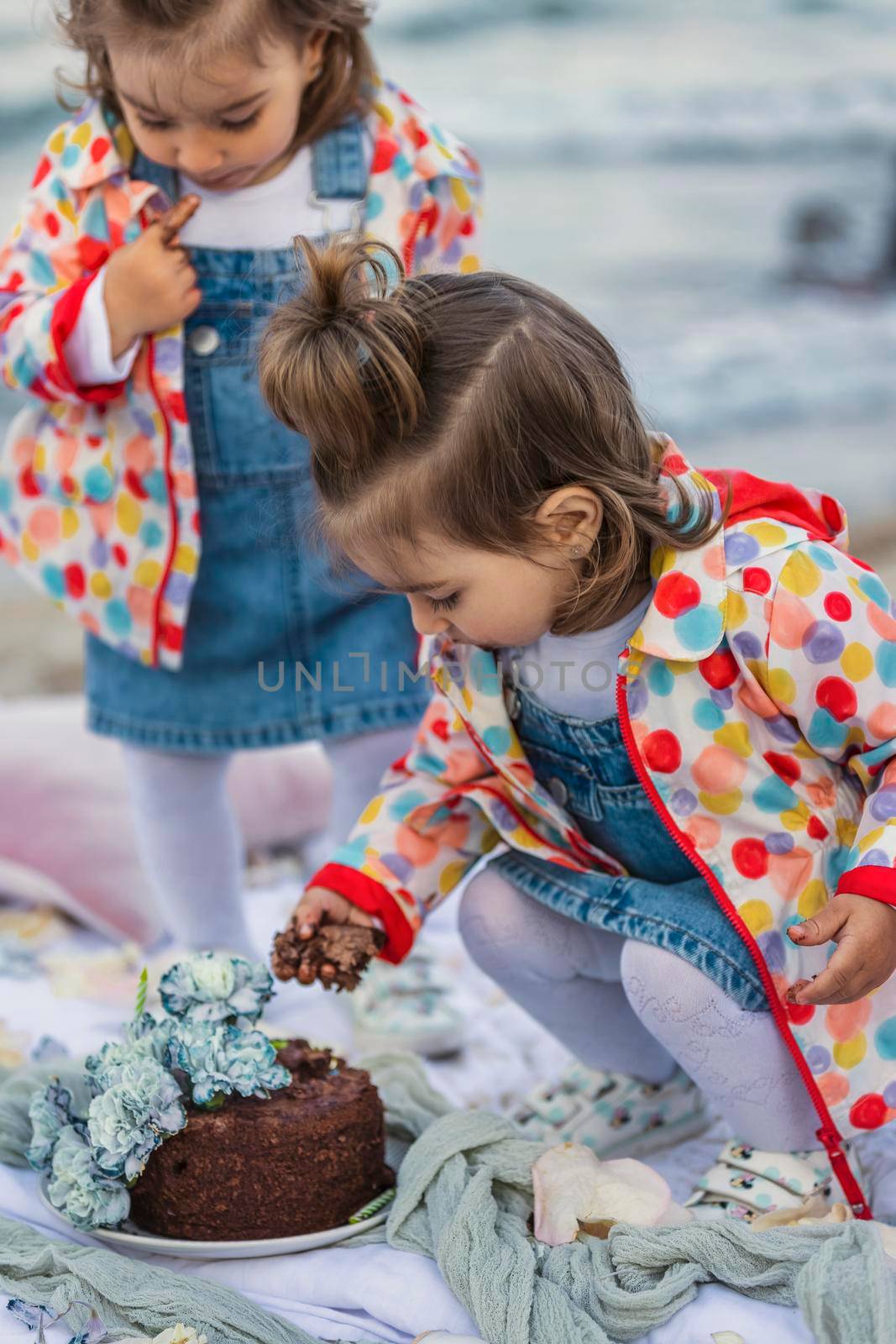 children eat chocolate covered cake with their hands