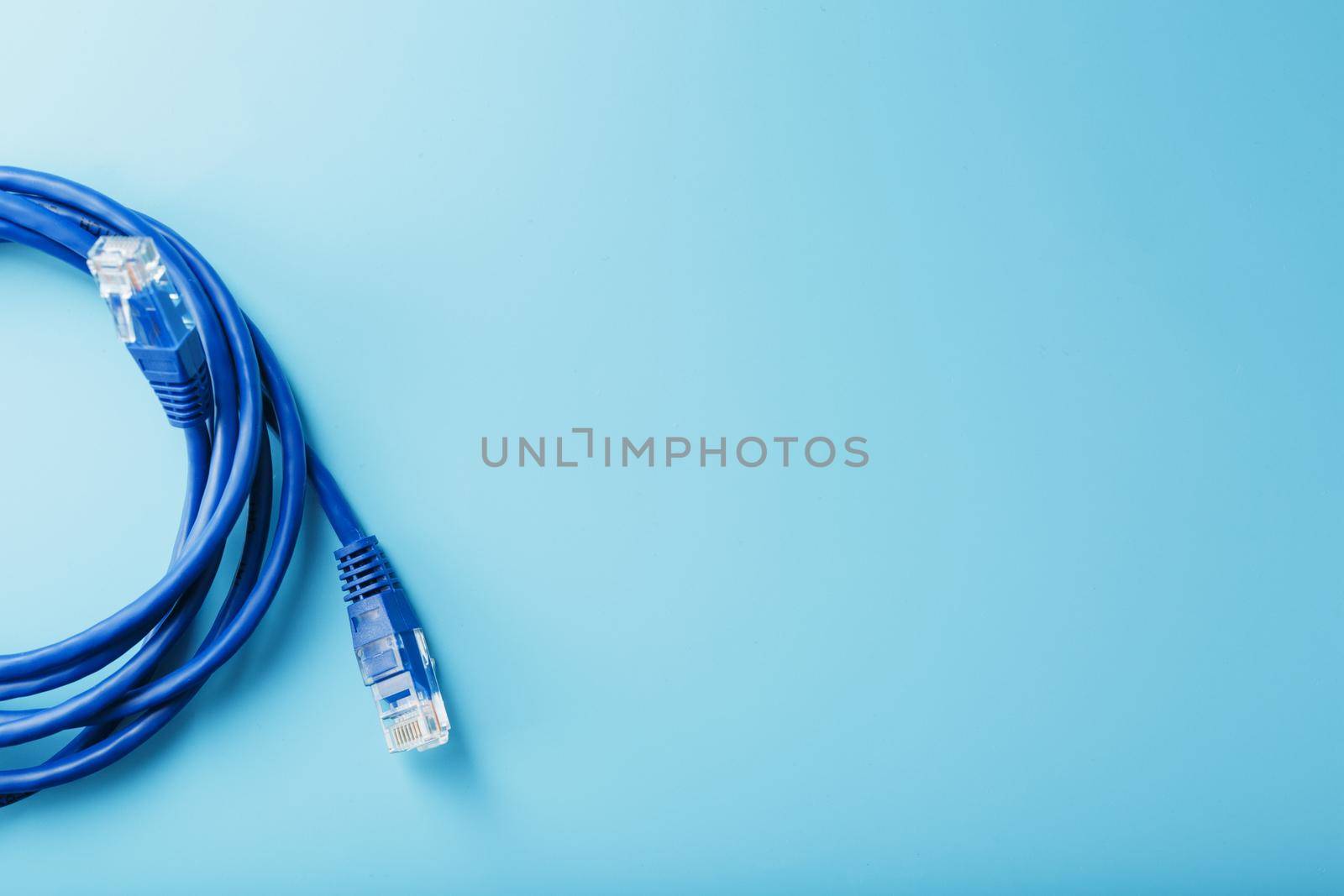 A coil of an Internet network cable for data transmission on a blue background by AlexGrec