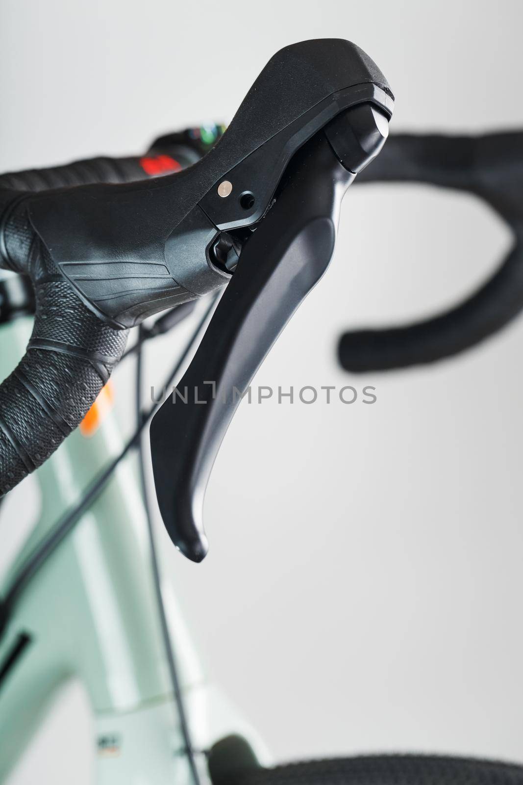 Highway bicycle handlebar in black winding and with brake gearshift knobs on a gray background.