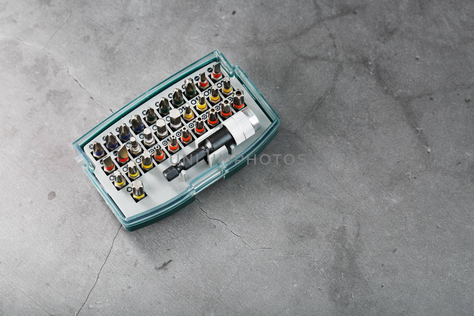 A set of metal power bits in a box on a gray background by AlexGrec