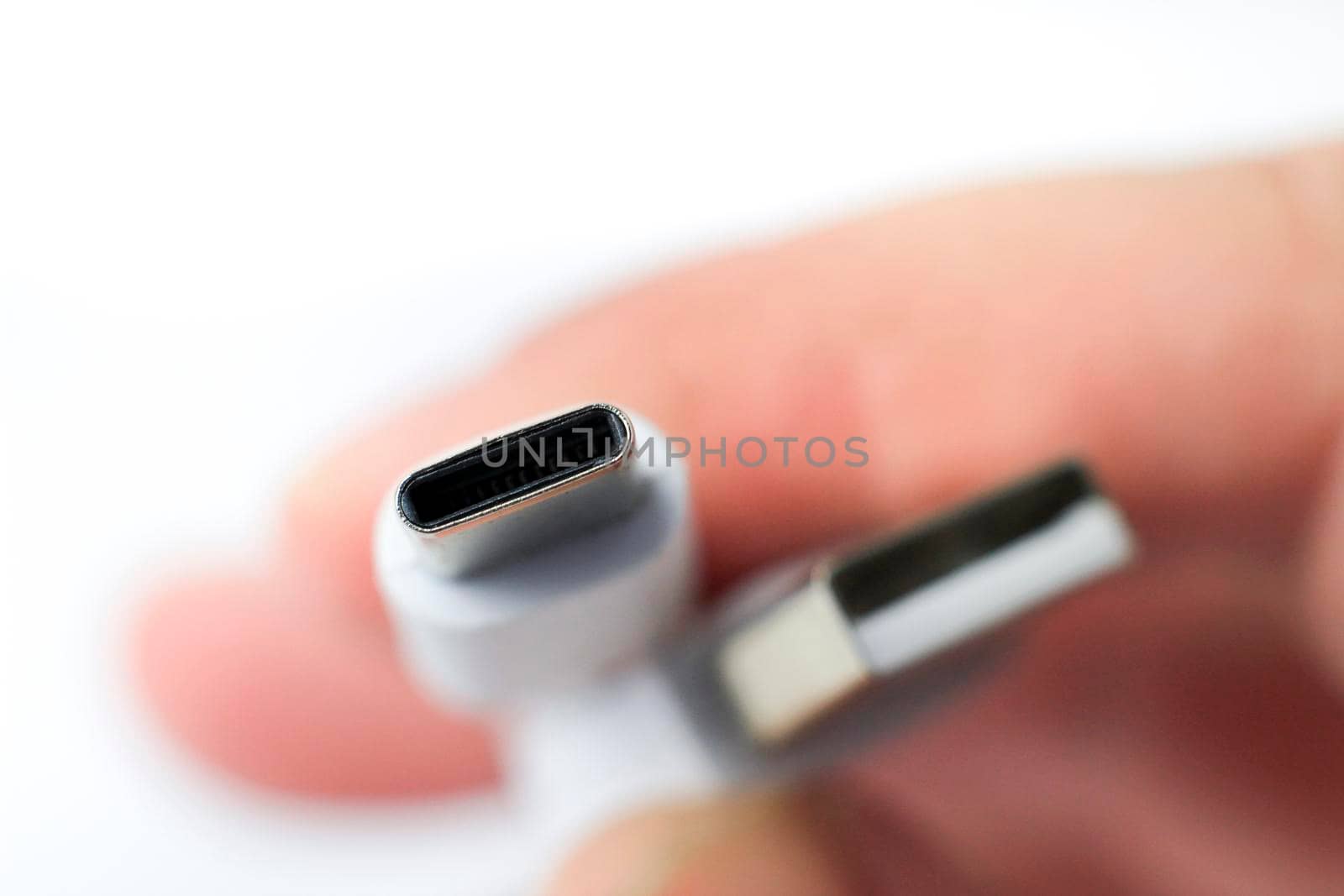 Hand holding USB-C type cable connector by soniabonet