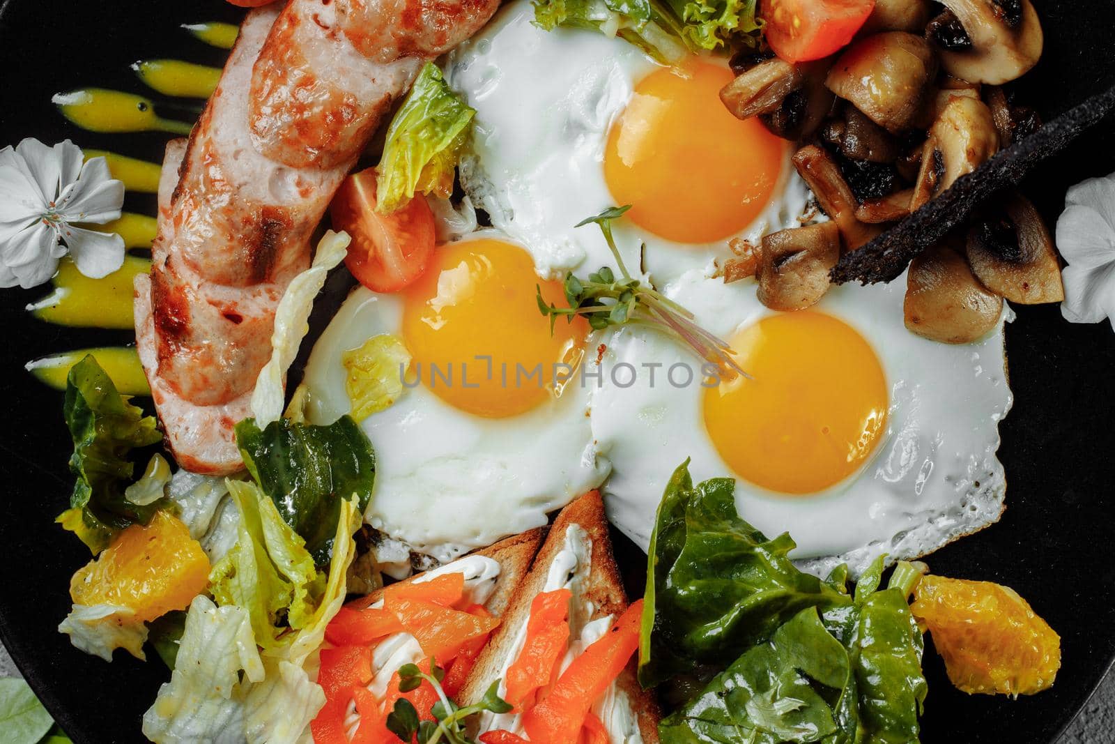 Full English breakfast with toast bread, chicken egg, mustard sauce, champignons, salad mix, cheese cream, sweet pepper.