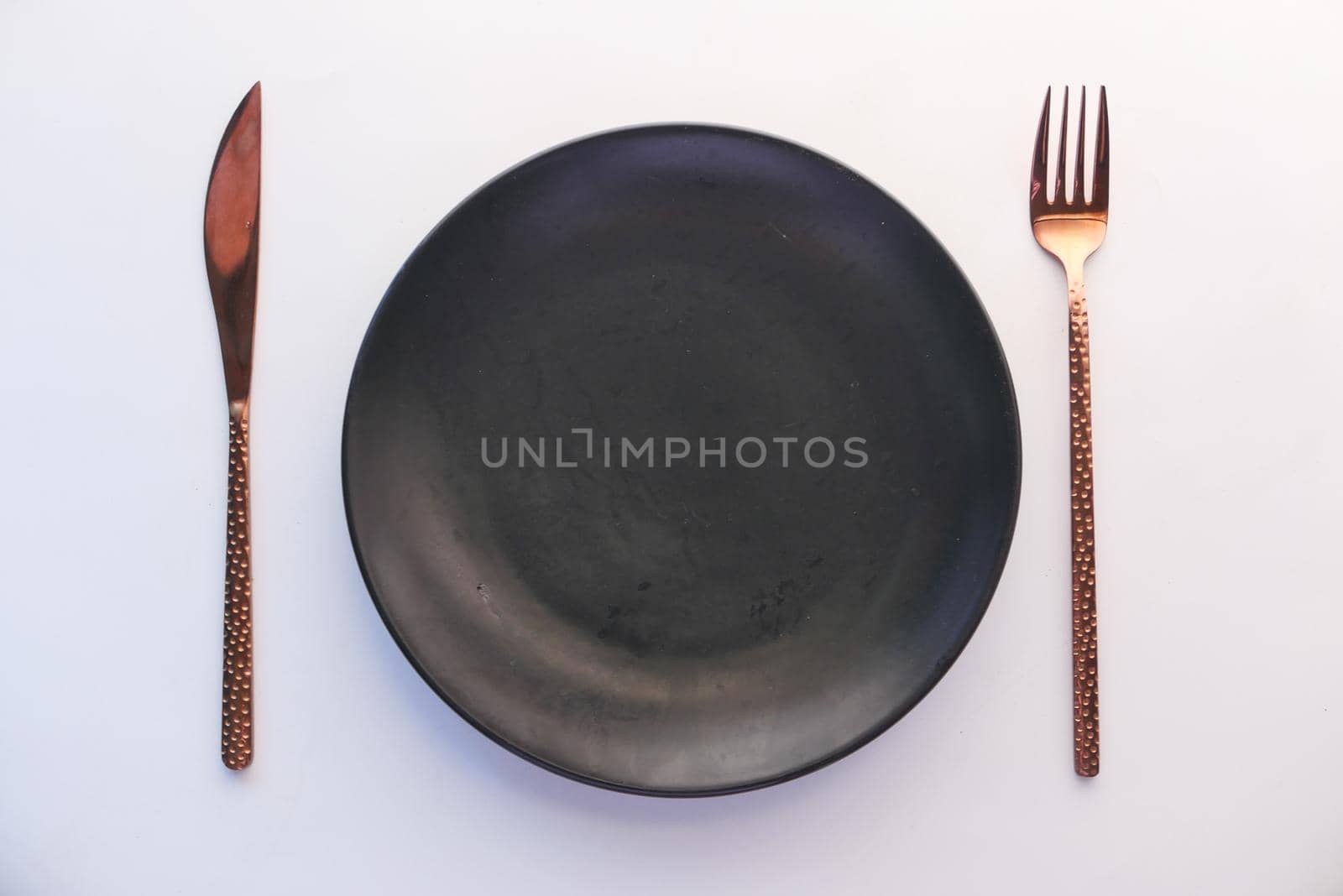 cutlery and empty plate on white background top down.
