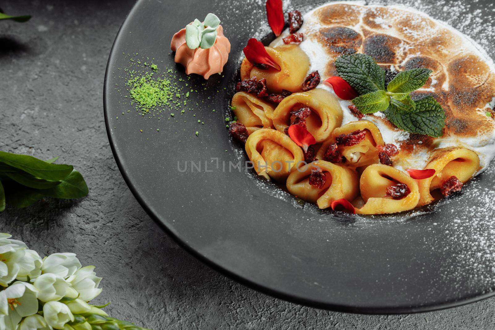 Pancakes with cheese in orange sauce served with caramelized nuts and almonds. Appetizing dish. Culinary photography, a proposal to serve a meal by UcheaD