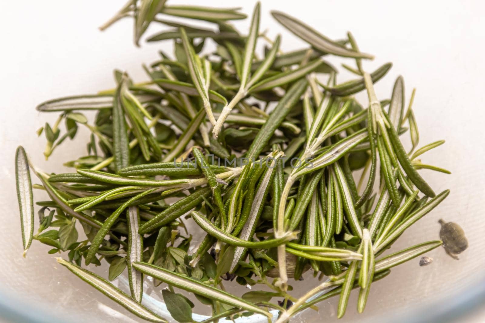 chopped fresh rosemary sprinkled on a white background. Aromatic spice rosemary isolated on white.