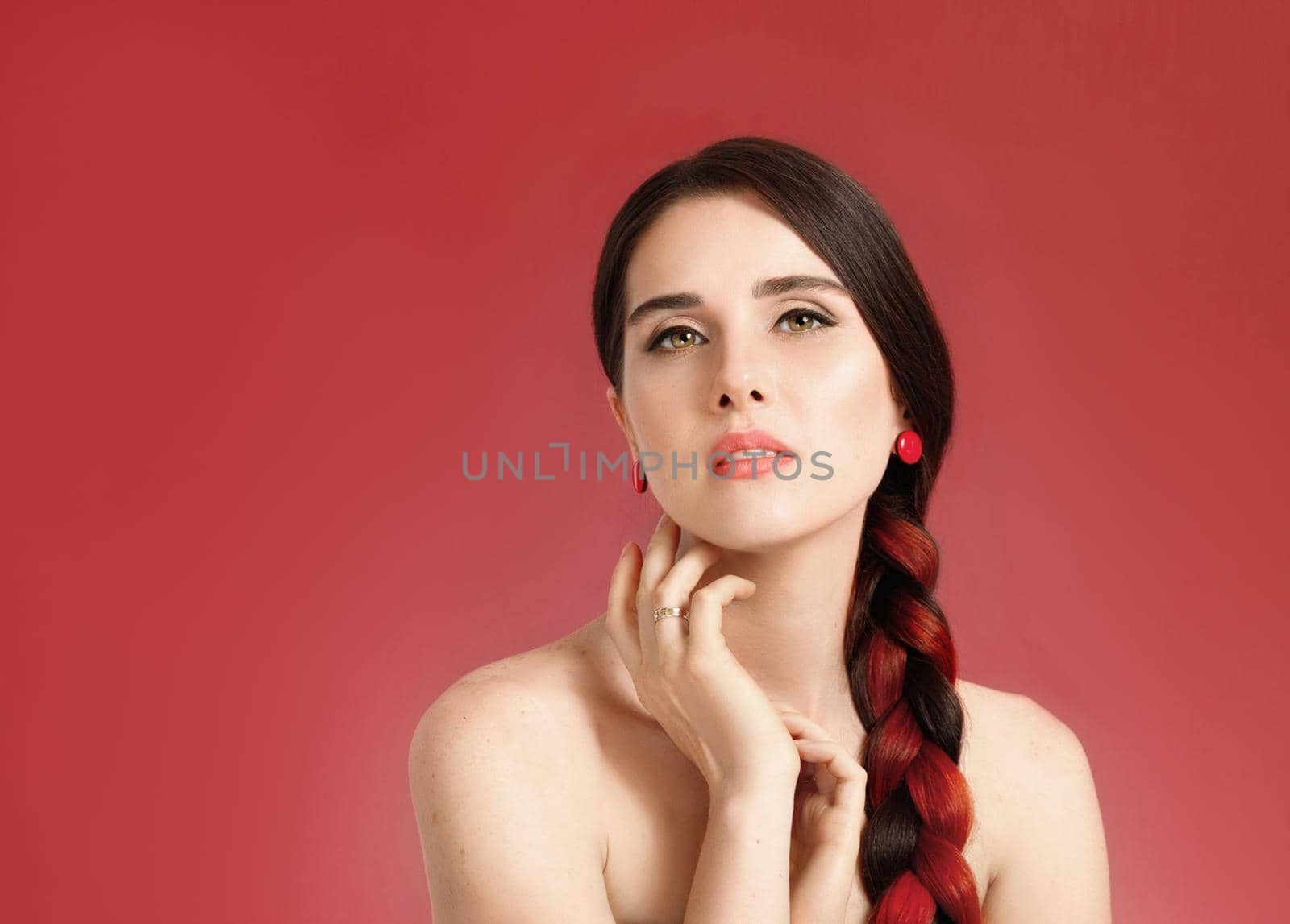 Portrait of a young beautiful well-groomed half-naked tender woman on a coral background, look at amera.