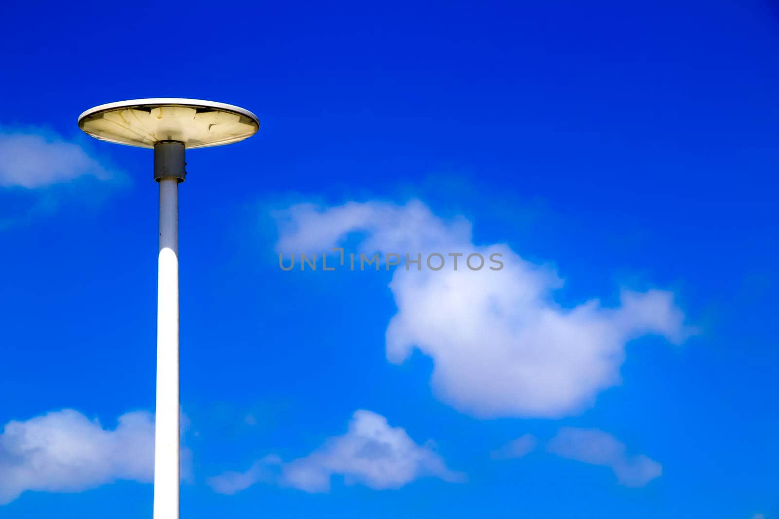 White lamppost in the morning under blue sky by soniabonet