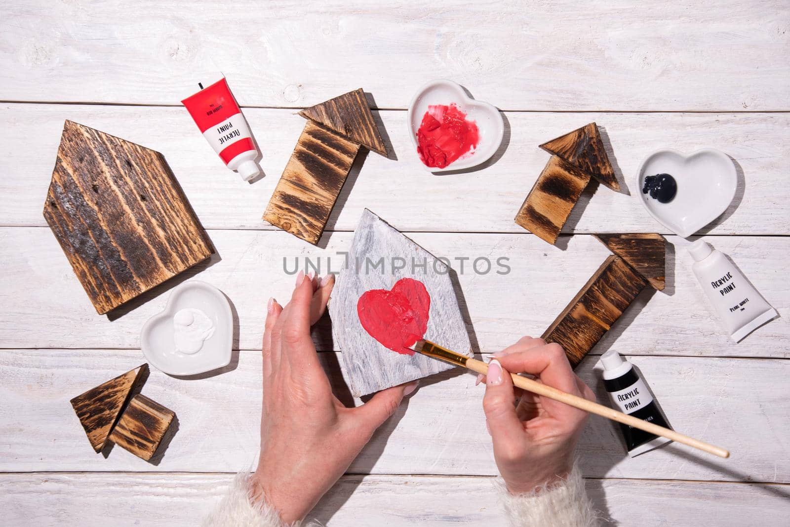 female hands draw a heart on a wooden house,step by step diy,crafting Sweet Home by KaterinaDalemans