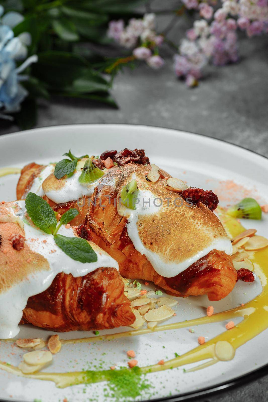 croissant with sweet cream and almonds on a plate. Delicious and healthy breakfast.