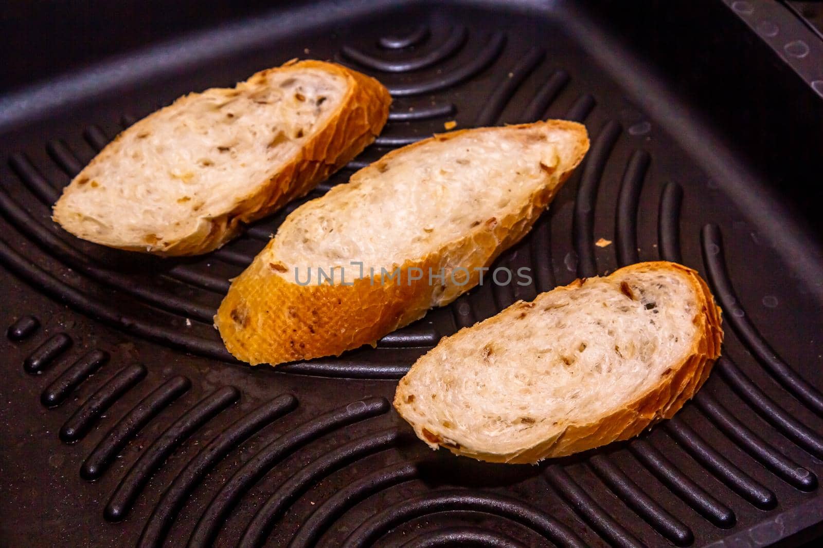 White bread toasted on an outdoor Grill on wooden table.