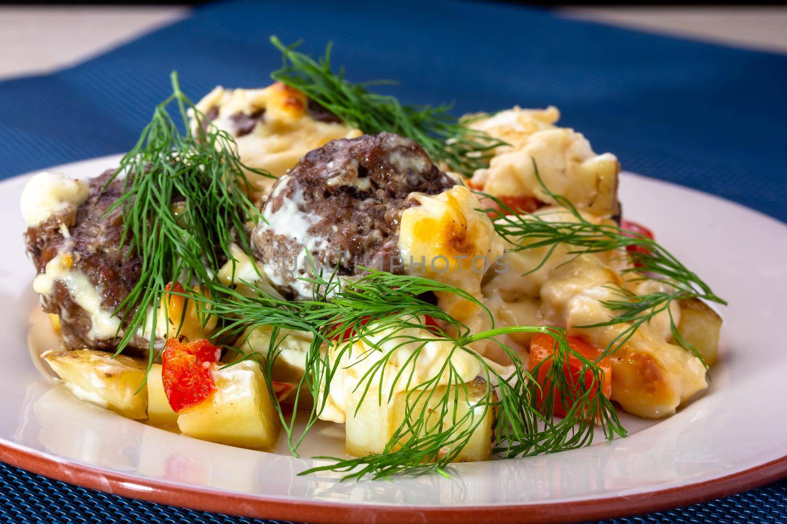 Delicious German meatballs in caper sauce served with boiled potatoes close-up in a plate on the table. Horizontal
