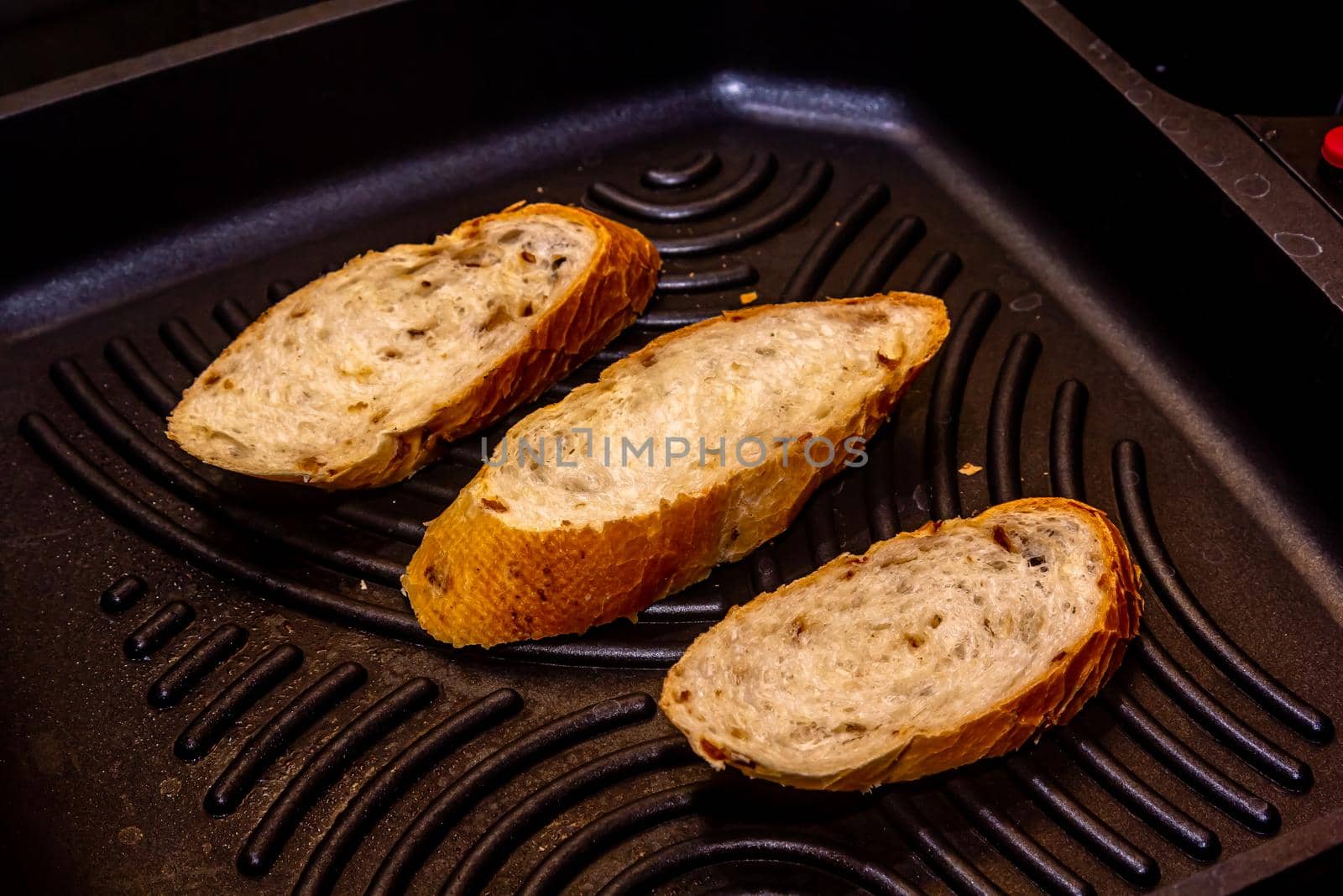 White bread toasted on an outdoor Grill on wooden table.