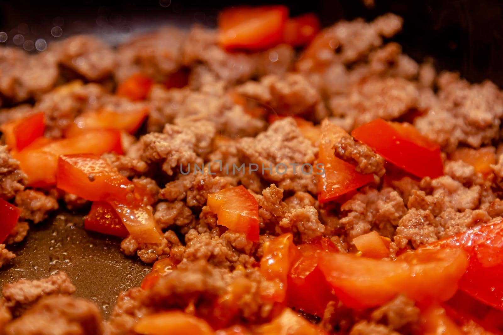 Bolognese ragout in a frying pan with wooden spoon, authentic recipe, close-up.