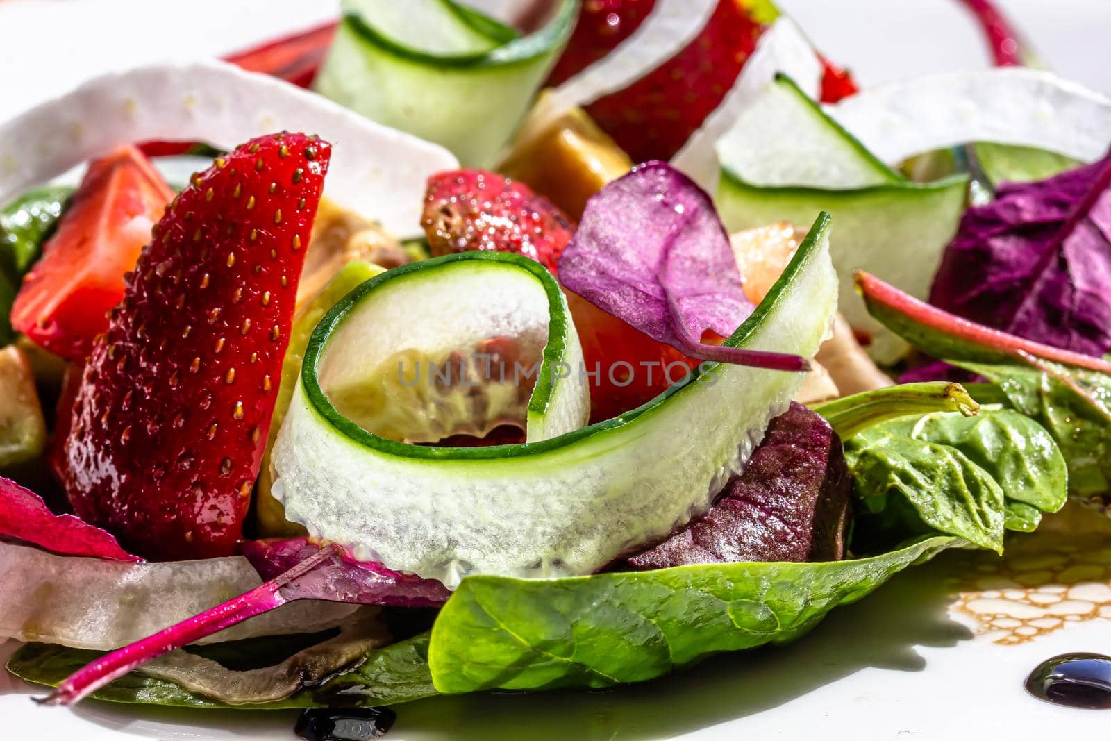 Summer Strawberry, cucumber salad with lettuce, feta cheese and almonds. Healthy Food by Milanchikov