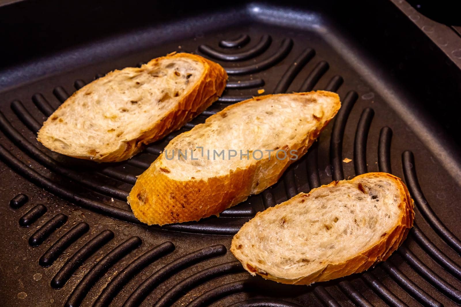 White bread toasted on an outdoor Grill on wooden table.