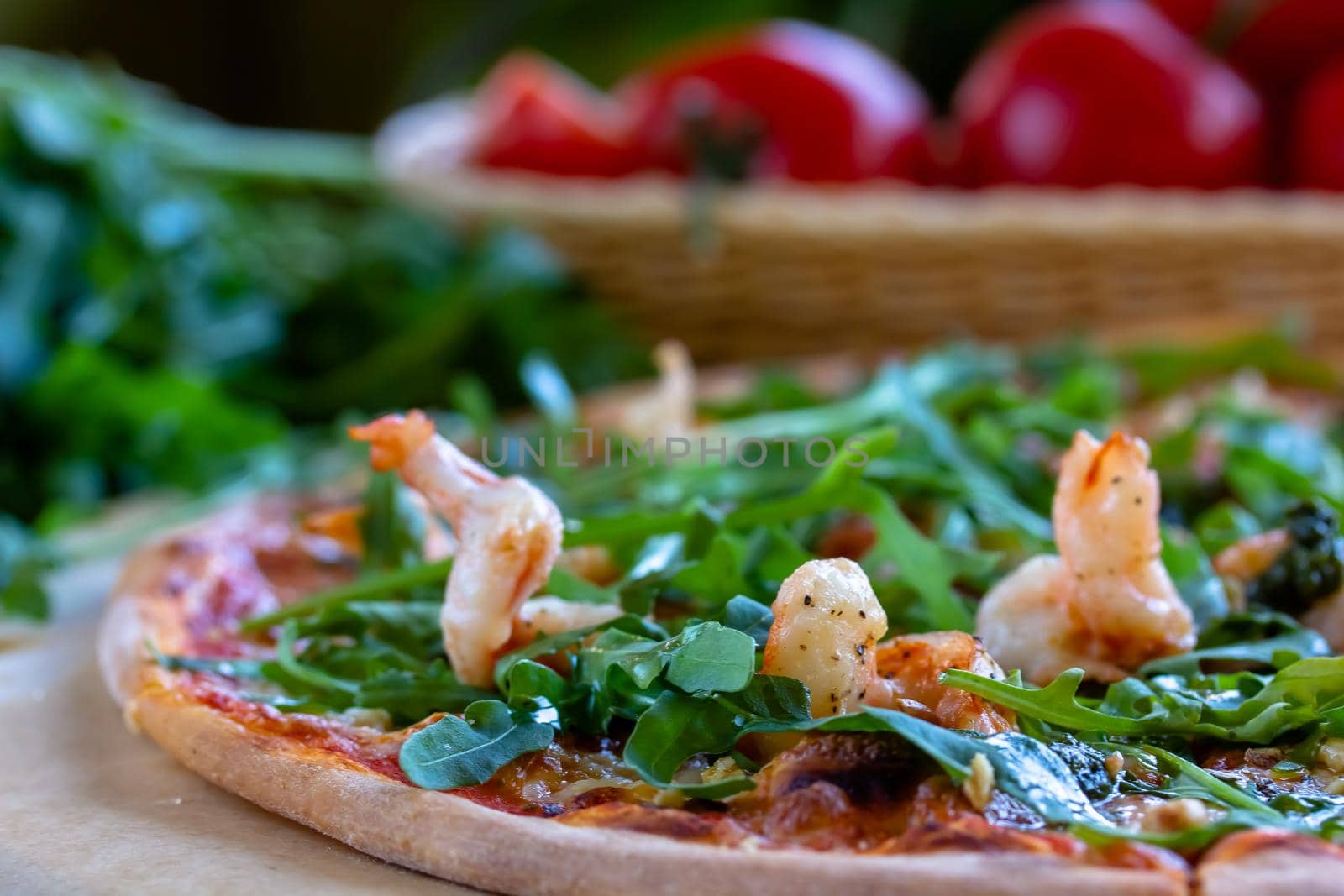 Delicious rustic Italian pizza with grilled Adriatic shrimps, mozzarella, sun dried tomatoes, arugula and parmesan cheese by Milanchikov