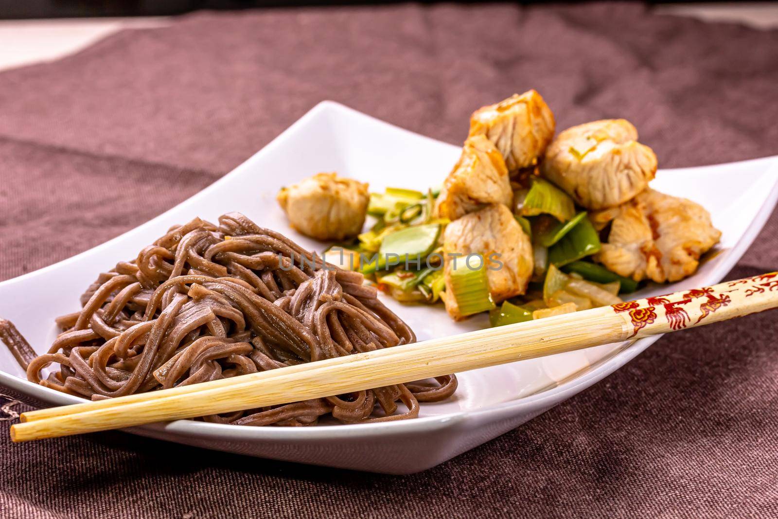 Japanese buckwheat noodles Yakisoba with chicken and vegetables on a light background.