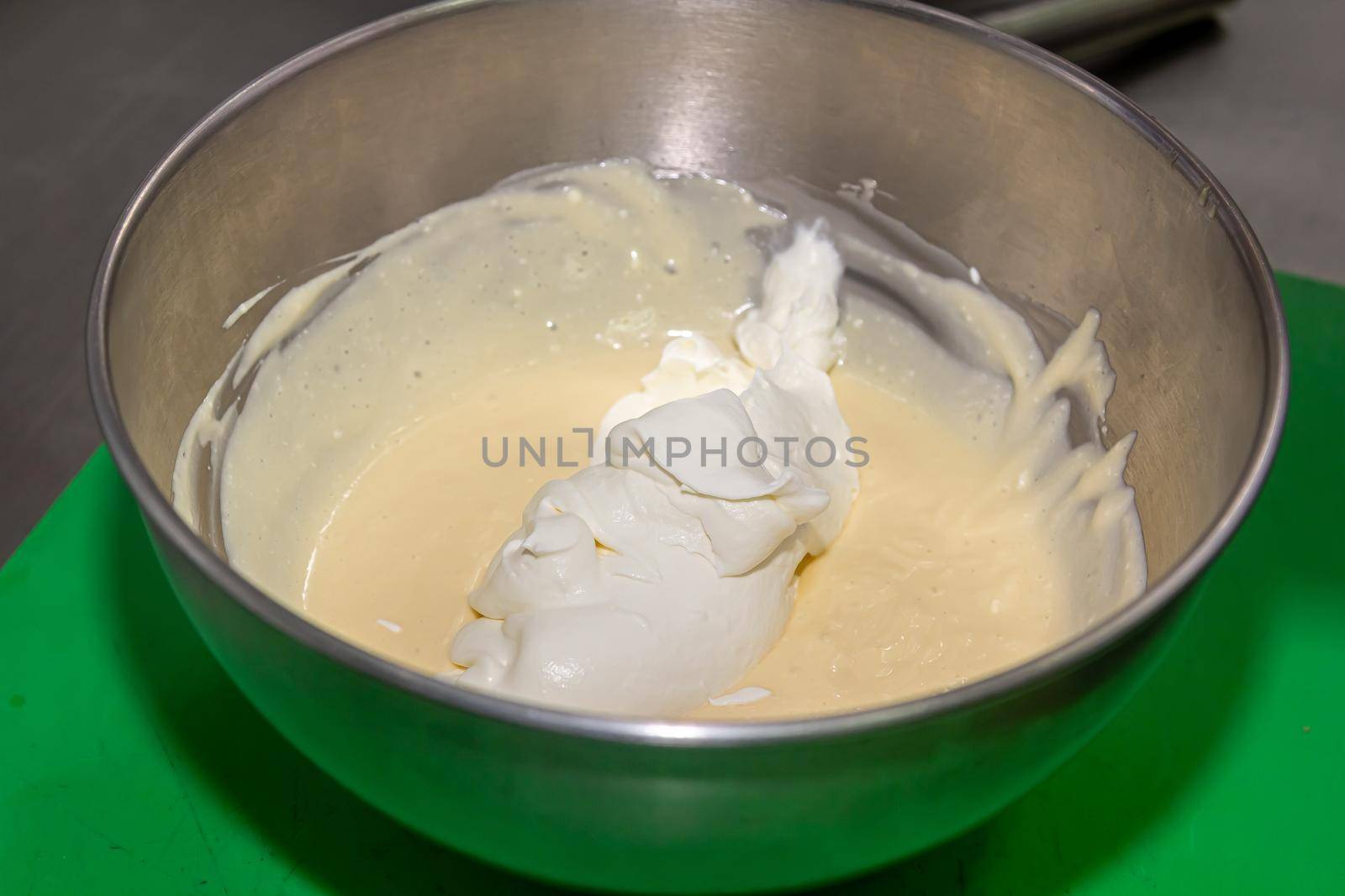 whisking egg yolks and sugar in a bowl.