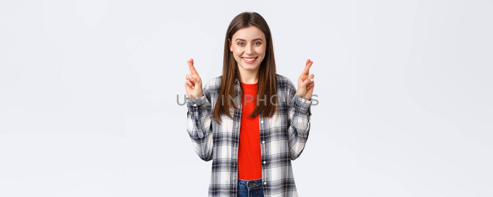 Lifestyle, different emotions, leisure activities concept. Hopeful cute caucasian girl in checked shirt, making wish, cross fingers good luck and smiling optimistic, white background by Benzoix