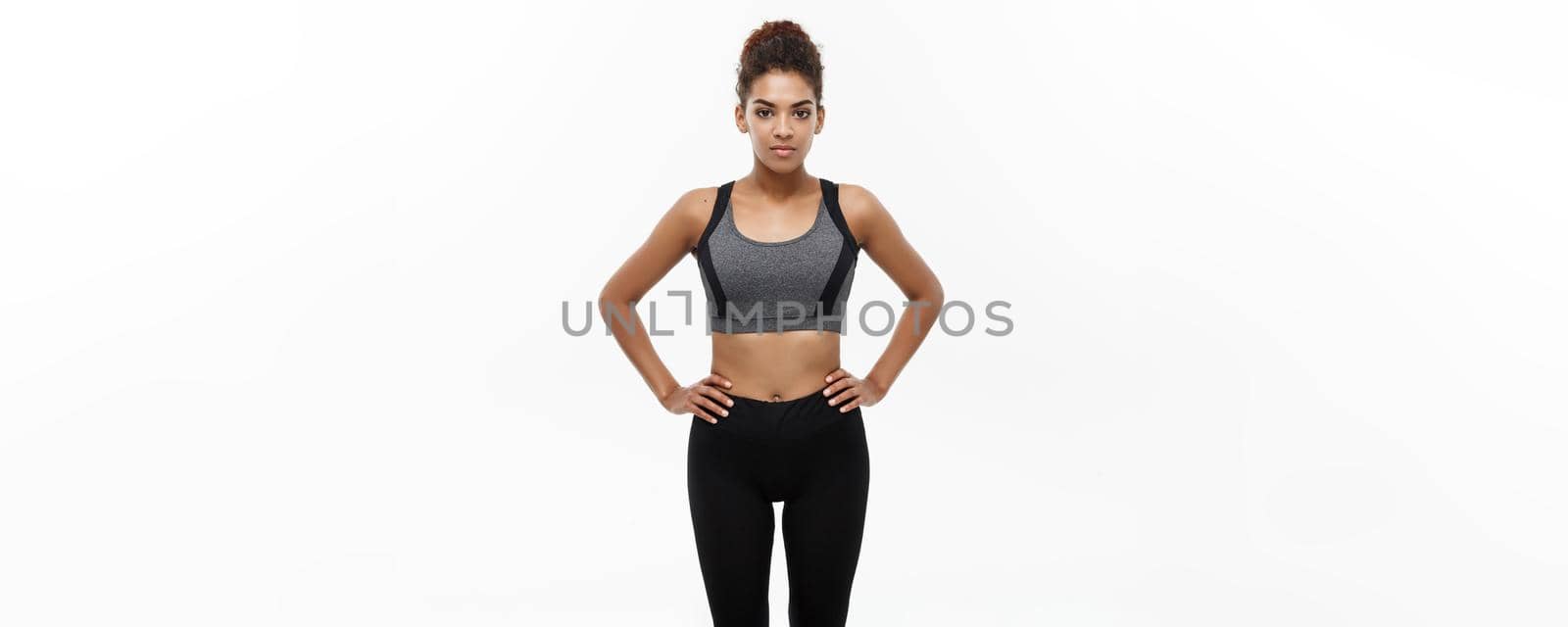 Healthy and Fitness concept - Beautiful American African lady in fitness clothes ready for workout. Isolated on white background