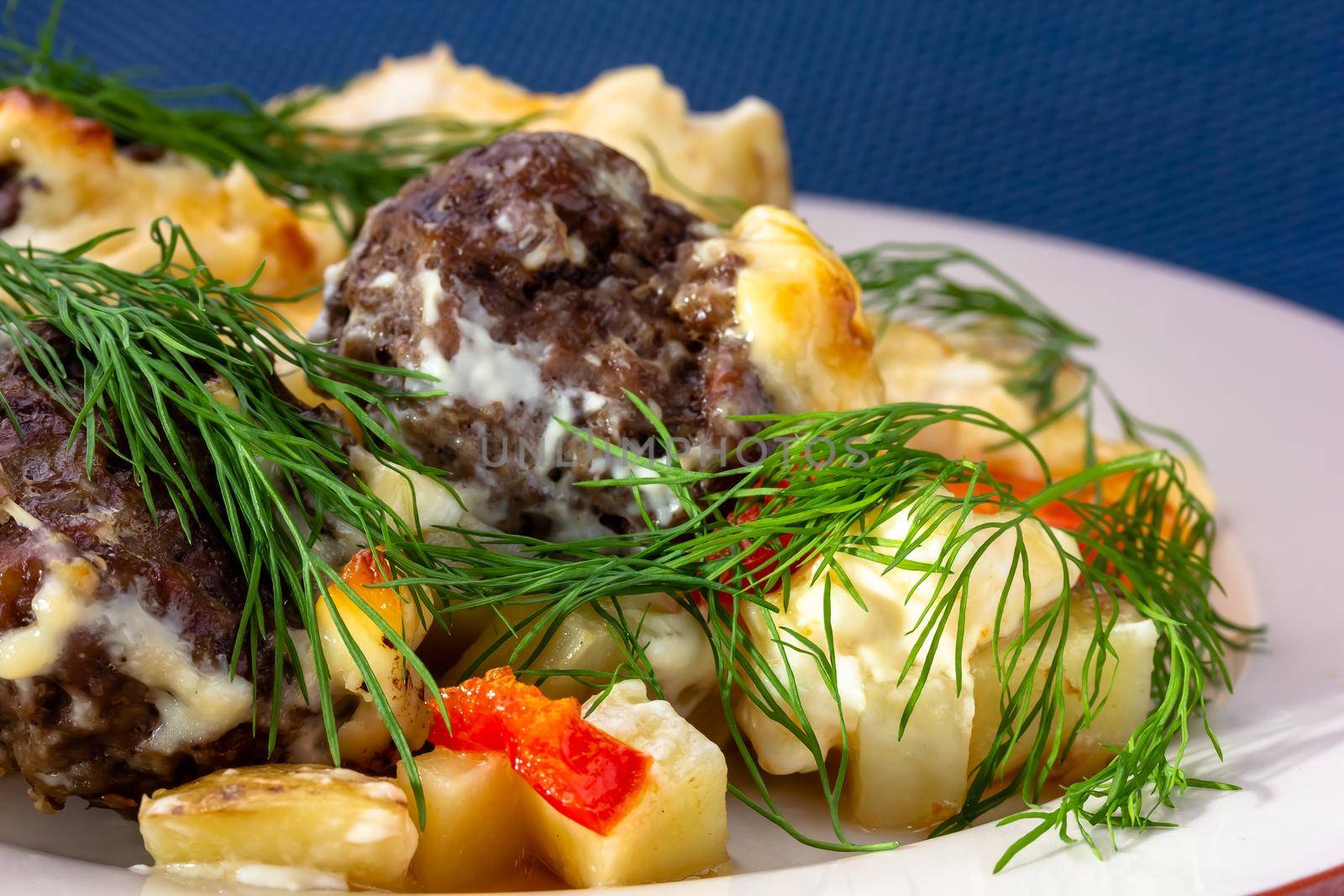 Delicious German meatballs in caper sauce served with boiled potatoes close-up in a plate on the table. Horizontal