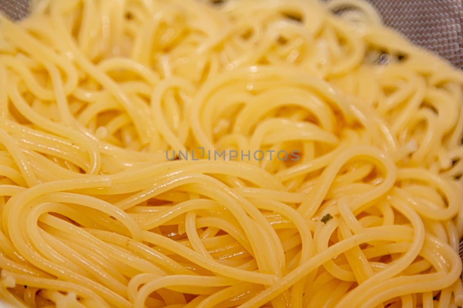 Closeup view of fresh boiled spaghetti pasta inside colander. Shallow depth of field by Milanchikov