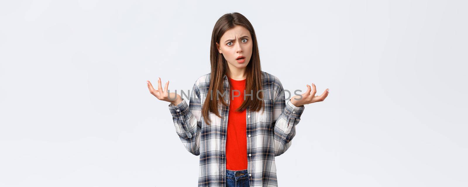 Lifestyle, different emotions, leisure activities concept. Frustrated and confused young woman asking for answers, shrugging with hands spread sideways, stare camera bothered with strange situation.