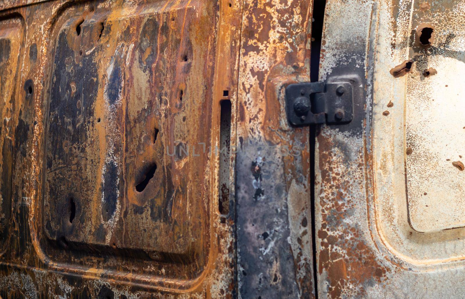 Burnt car body riddled with bullets. Russia's war against Ukraine. Shot by the Russian military car of civilians during the evacuation. Traces of bullets and fragments of shells