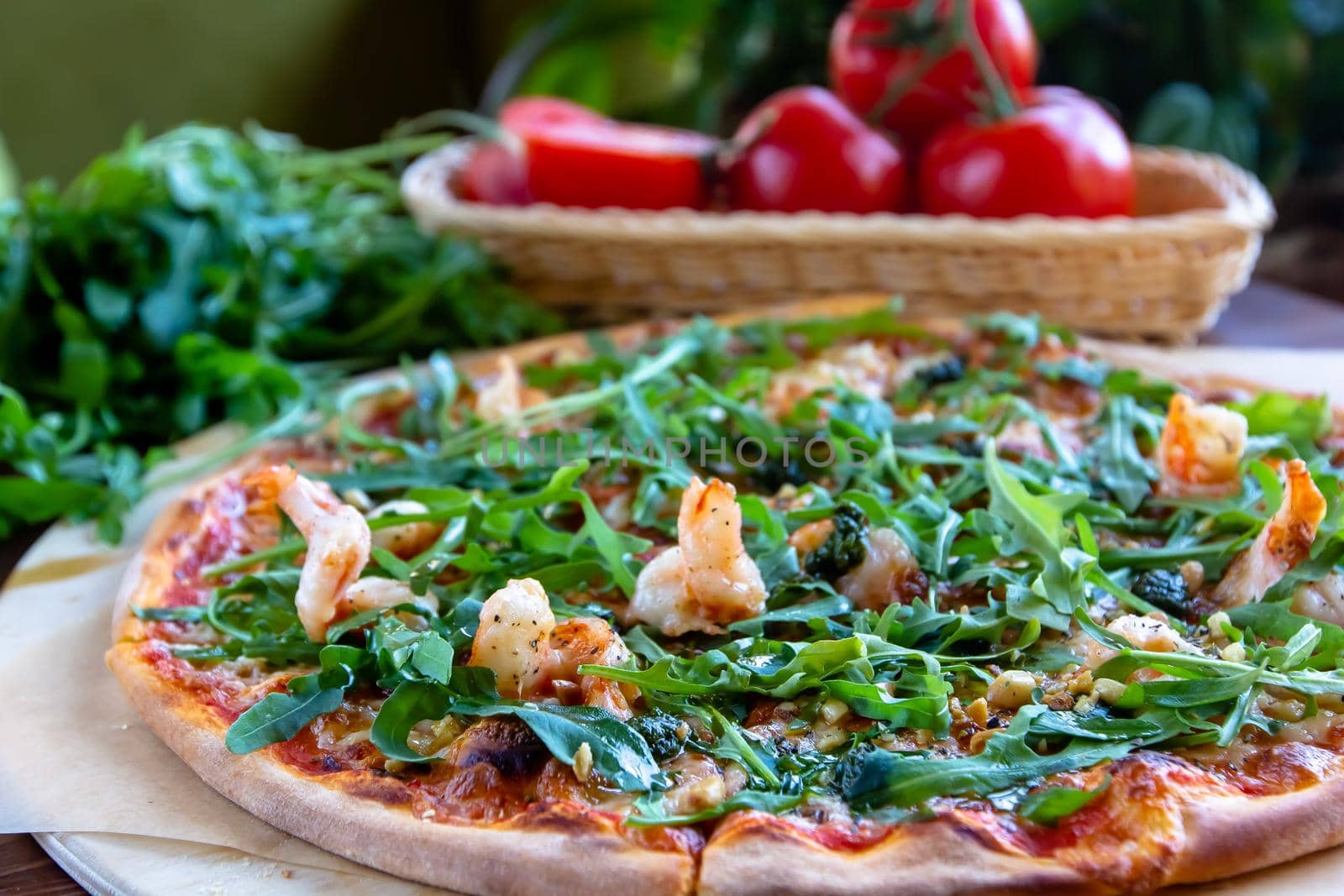 Delicious rustic Italian pizza with grilled Adriatic shrimps, mozzarella, sun dried tomatoes, arugula and parmesan cheese by Milanchikov