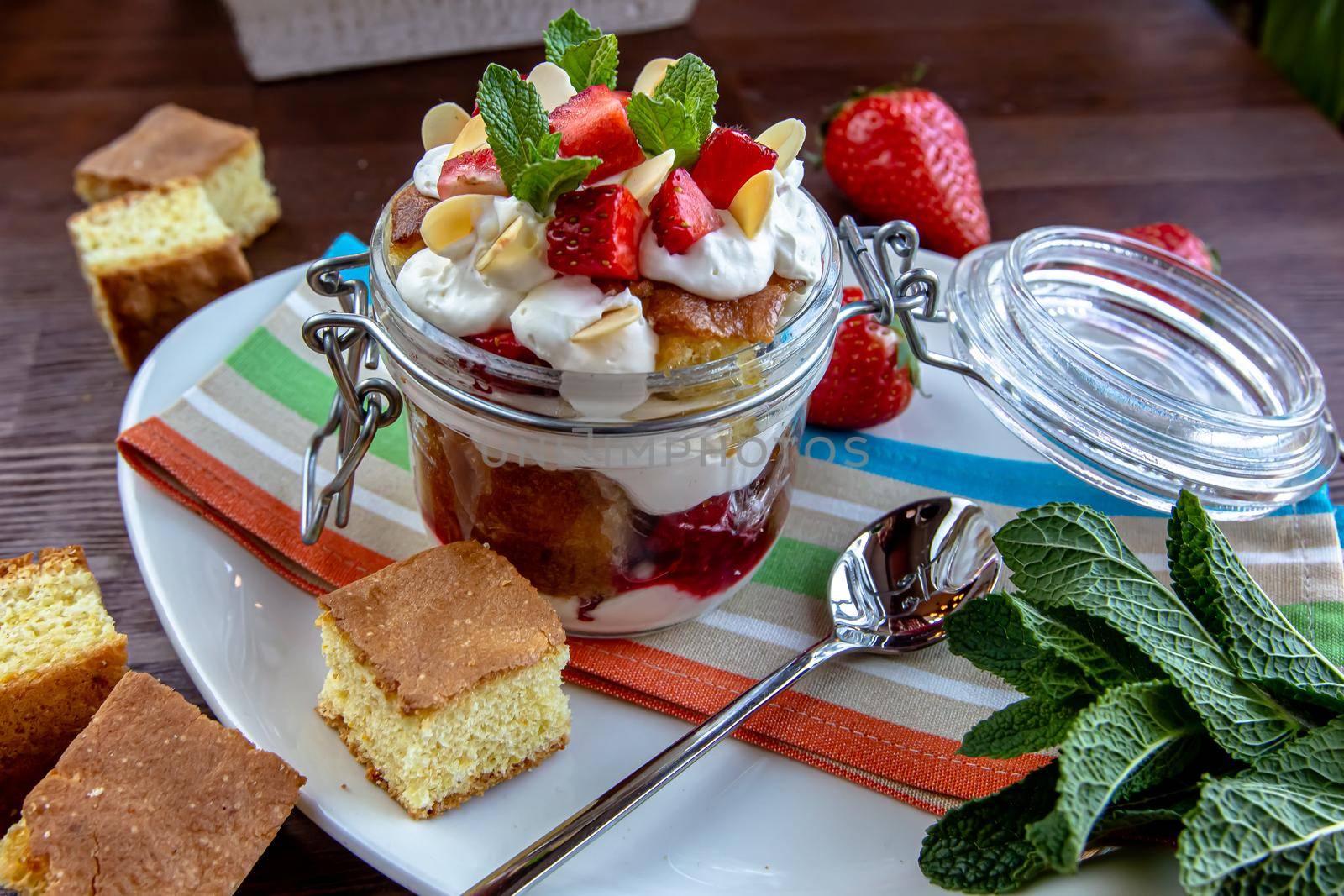 Layered Dessert of chocolate sponge cake, whipped cream or ricotta and fresh strawberries in a glass bowl. Trifle. Delicious gourmet breakfast. Selective Focus, copy space