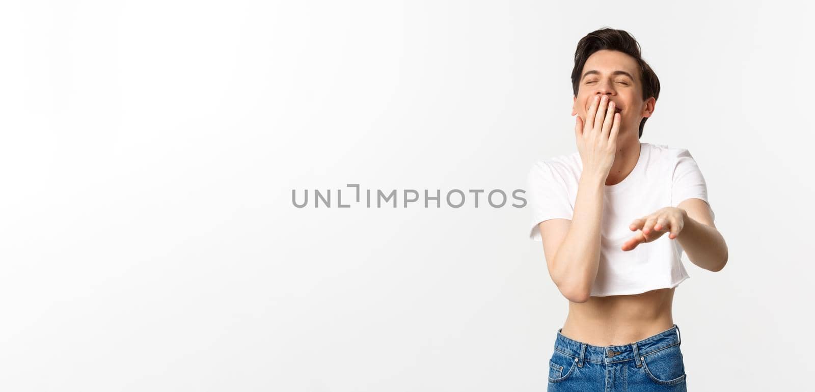 Lgbtq and pride concept. Image of silly gay man in crop top laughing and pointing hand at camera, chuckle over funny joke, white background.