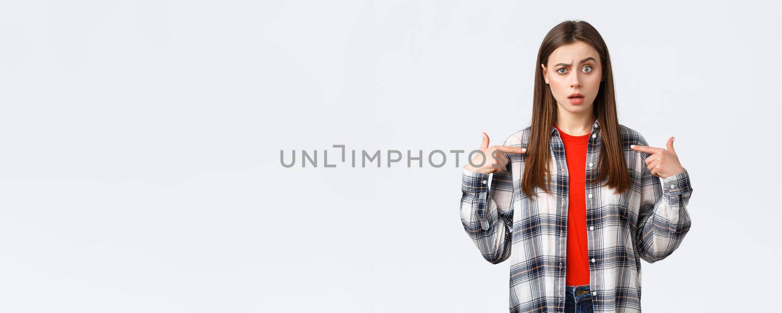 Lifestyle, different emotions, leisure activities concept. Confused young girl cant understand why she. Puzzled woman pointing at herself with raised eyebrow, being chosen, white background by Benzoix