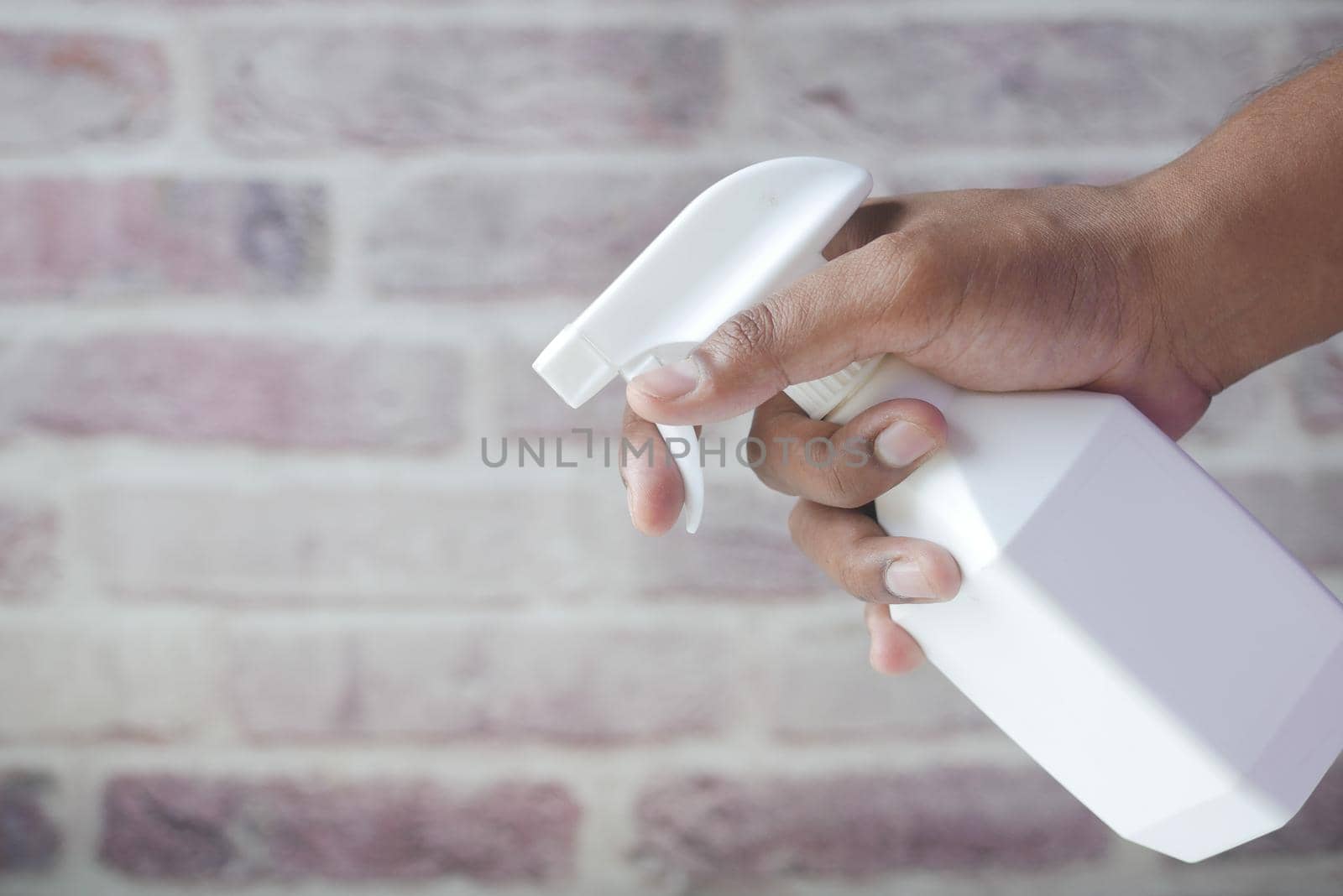holding white color spray bottle with copy space .