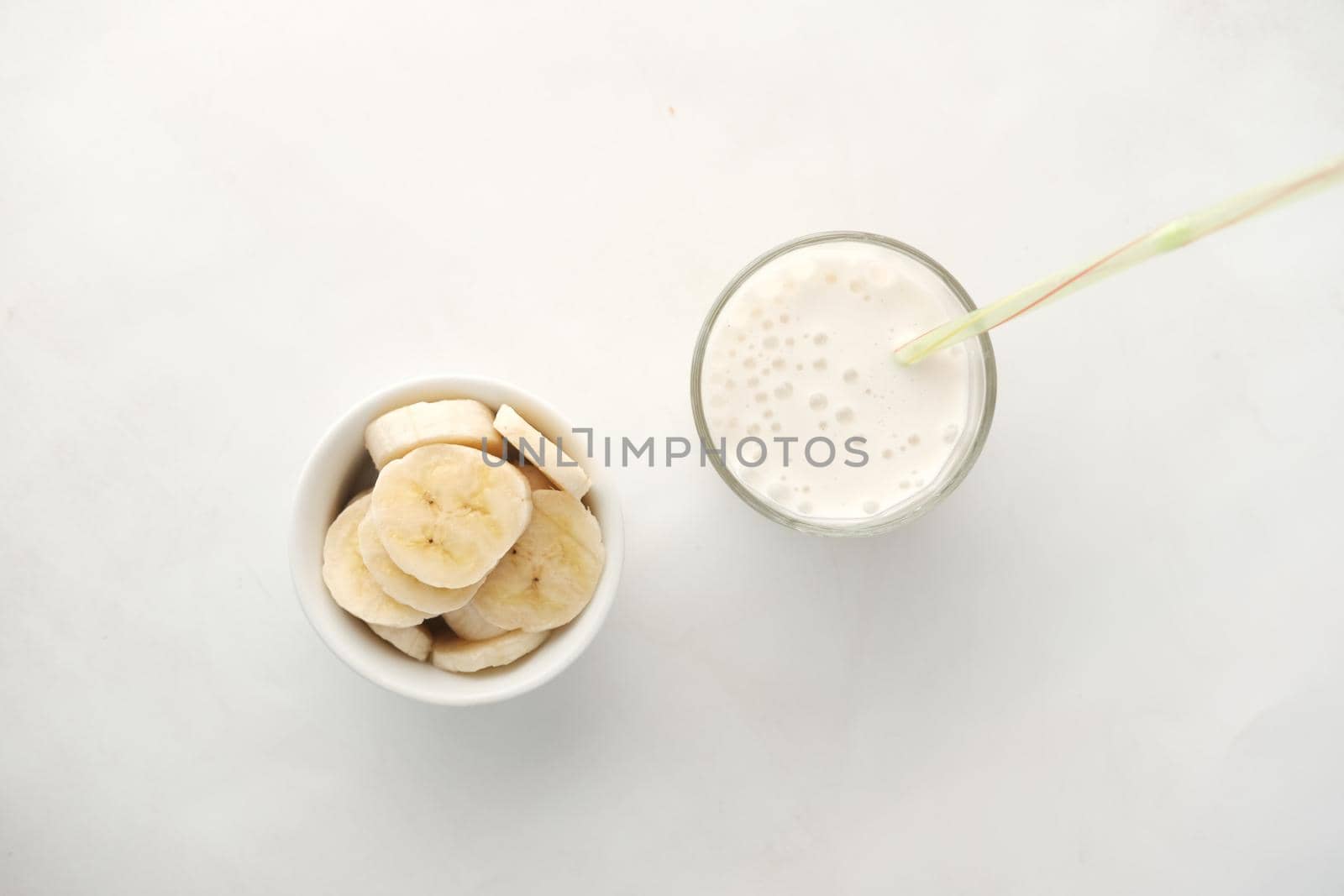 glass of milk and banana on table at morning .