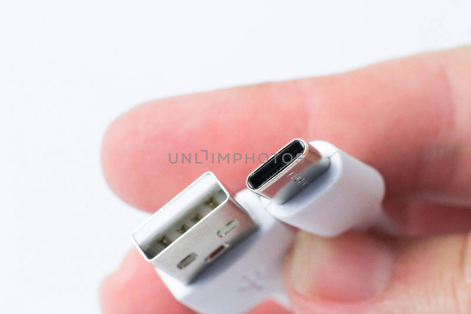 Hand holding USB-C type cable connector by soniabonet