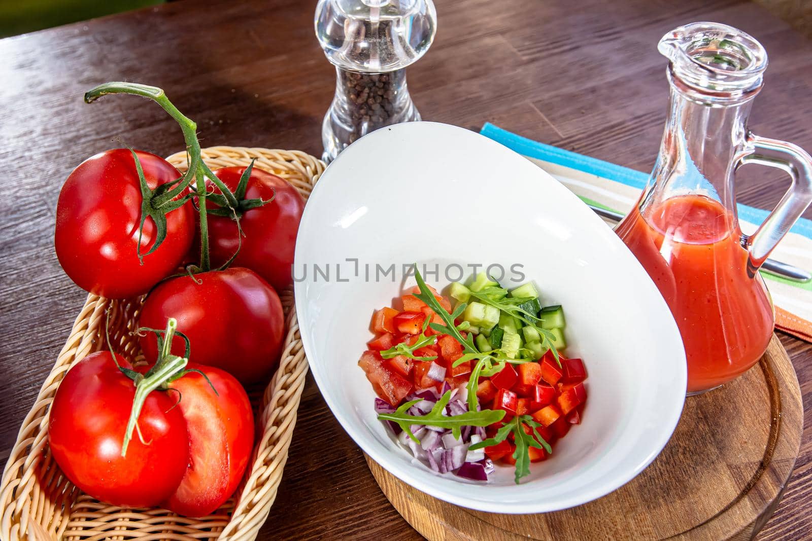 Tasty appetizing summer tomato soup puree gazpacho with tomatoes and cucumbers served in bowl by Milanchikov