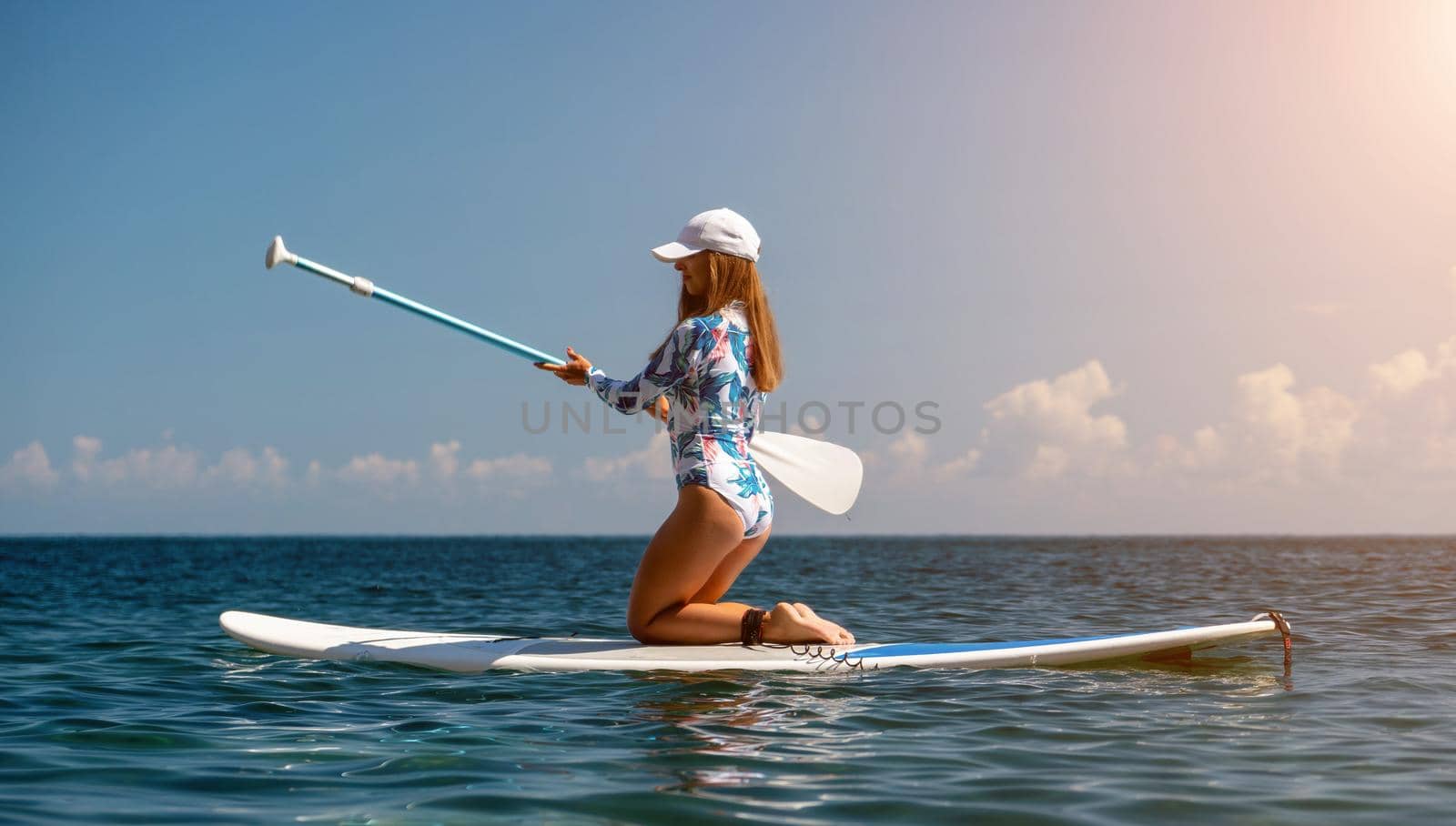 SUP Stand up paddle board. Young woman sailing on beautiful calm sea with crystal clear water. The concept of an summer holidays vacation travel, relax, active and healthy life in harmony with nature